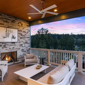 Luxury covered outdoor living with a cozy gas fireplace and expansive patio doors