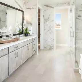 Lavish primary bathrooms with large walk-in showers and ample counter space