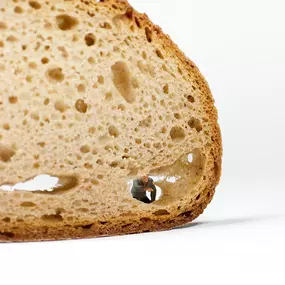 SW Kommunikation Kreatives Food-Design mit einer Brotscheibe und einer kleinen Figur in einem Hohlraum, surreal und detailreich