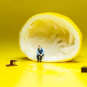 SW Kommunikation Surreales Design mit einer halben Zitrone und einer winzigen Figur, kreative Darstellung in leuchtendem Gelb