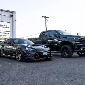 Toyota 86 TRD and a lifted Chevrolet Silverado parked outside VersionEX Auto in Eugene, OR. The photo highlights the shop’s expertise in automotive customization, from performance styling and wraps to truck upgrades and protective coatings.