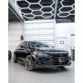 Black Honda Accord with bronze wheels inside VersionEX Auto’s detailing bay in Eugene, OR. The polished finish and custom styling showcase the shop’s expertise in ceramic coating, performance upgrades, and high-quality vehicle maintenance.