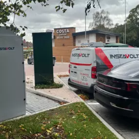 Electric vehicles are plugged into InstaVolt ultra-rapid chargers next to Costa Coffee Drive Thru at Topaz Business Park, Bromsgrove. The location is clearly signposted and features branded InstaVolt support vehicles, making it convenient for drivers to recharge while enjoying refreshments.