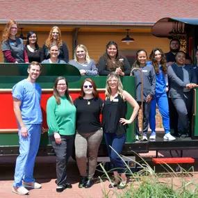 The Yukon dental team poses in from of the model train at Dental Depot's Yukon dental office