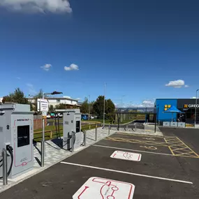 Two InstaVolt ultra-rapid chargers located beside Greggs Drive Thru in Bicester, with clearly marked EV bays, cycle shelter, and ample parking.