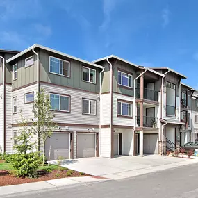 A row of modern townhouses with a clear blue sky above.