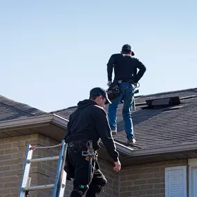 Two LS Contracting roofers performing a residential roof inspection and minor shingle repair in Southeast Louisiana. Professional roofing service ensuring storm-ready protection.