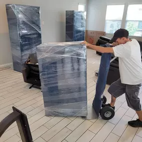 Donation Movers team member handling packed and wrapped items with care during a move.