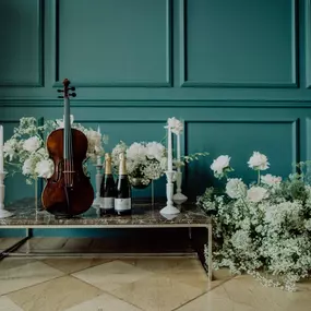 dunkelgoldmusik | Hochzeits- und Veranstaltungsmusik Romantische Dekoration mit Viola, Blumen und Champagner – Symbol für festliche Hochzeitsmusik. Foto von Sabography24.