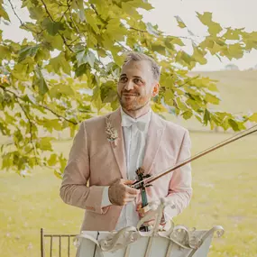 dunkelgoldmusik | Hochzeits- und Veranstaltungsmusik Musiker sorgt mit romantischer Violamusik bei einer Trauung im Freien für festliche Stimmung. Foto von Lisa Reich.