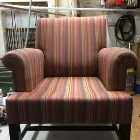 Martin Otto Thie Raumgestaltung Inh. Aline Sander e.K. Handgefertigter Sessel mit farbiger Streifenpolsterung, aufgearbeitet in einer Werkstatt. Beispiel klassischer Polsterarbeit mit Stoffauswahl und handwerklicher Präzision.
