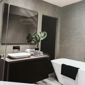 Martin Otto Thie Raumgestaltung Inh. Aline Sander e.K. elegantes Badezimmerdesign in warmen Naturtönen mit freistehender Badewanne. Kombination aus Minimalismus und wohnlicher Atmosphäre in der Raumgestaltung.