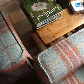 Martin Otto Thie Raumgestaltung Inh. Aline Sander e.K. Detailansicht eines Sofas mit hochwertigem karierten Wollstoff in Blau-Rot. Saubere Nähte und exakte Verarbeitung zeigen die handwerkliche Präzision in Polsterarbeiten und Stoffauswahl.