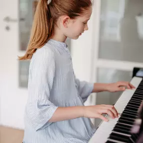 Elite Musik Ein Kind zeigt volle Konzentration beim Klavierspielen und vermittelt musikalische Hingabe.