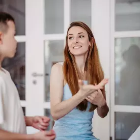 Elite Musik Eine Musiklehrerin gibt anschauliche Erklärungen und unterstützt den Schüler beim musikalischen Lernen.