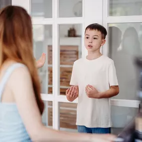 Elite Musik Ein Kind übt seine Stimme im Rahmen einer Gesangsstunde und zeigt aktive Beteiligung.