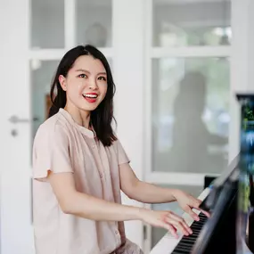 Elite Musik Eine Frau musiziert am Klavier und vermittelt Freude und Leidenschaft für Musik.