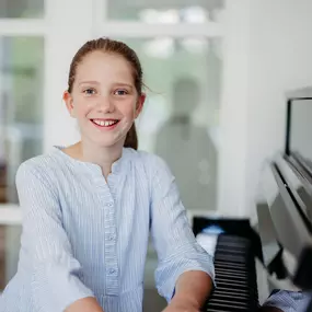 Elite Musik Ein natürliches Porträt eines Mädchens am Klavier, das musikalische Begeisterung ausstrahlt.