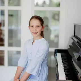 Elite Musik Ein Kind am Klavier in einem hellen Raum – perfekt für Themen wie Musikausbildung oder Talentförderung.