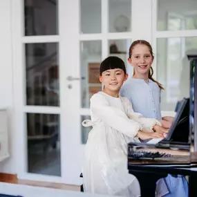 Elite Musik Ein harmonisches Bild zweier Kinder, die zusammen musizieren und gemeinsames Lernen zeigen.