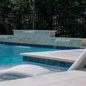 Pool ledge wall with scupper waterfall water features