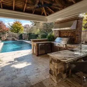 Outdoor kitchen and pool with spa and waterfall