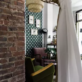 Schmierfink & Robird stilvolle loungeecke mit grünen und rosafarbenen sesseln, gemusterter tapete und vintage charme – einladendes ambiente für tattoo beratung in braunschweig