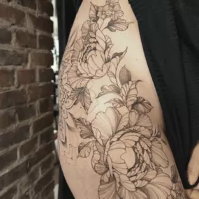 Schmierfink & Robird detailreiches blumentattoo mit feinen linien auf der haut, kunstvolle florale motive in filigraner tätowiertechnik
