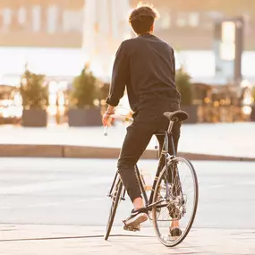 Ein Mann fährt in der warmen Abendsonne durch die Hamburger Hafencity. Das Bild vermittelt Freiheit, Leichtigkeit und urbanen Lifestyle im goldenen Licht des Sonnenuntergangs.