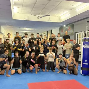 Gemeinschaftliches Kampfsporttraining in moderner Sportschule mit motivierten Teilnehmerinnen und Teilnehmern aller Altersgruppen.