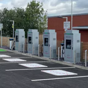 Wide-angle view of InstaVolt's ultra-rapid charging hub at Fenton, Stoke-on-Trent, showing multiple chargers, clean surroundings, and designated EV-only parking spaces.