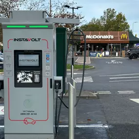 Close-up of an InstaVolt ultra-rapid charger positioned in front of a McDonald’s in Carlisle, showing easy access and convenient nearby dining.