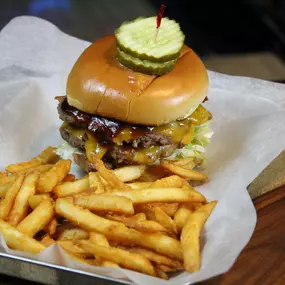 two smashed burgers layered with cheddar cheese, bacon, and bbq sauce (served with lettuce, tomato, onion, & pickle)