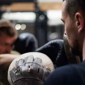 Personal Training Robert Reberger Kraftvolles Training mit Boxhandschuhen und Pads zur Verbesserung von Schnelligkeit und Reaktionsfähigkeit.