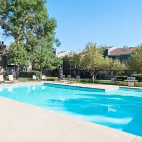 Swimming pool with large sundeck and lounge chairs.