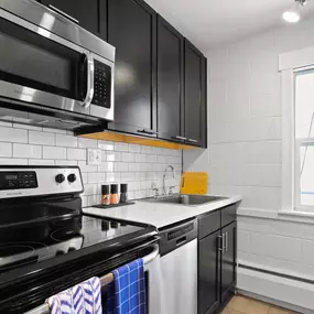 Spacious kitchen with stainless steel appliances and quartz countertops.