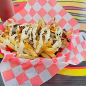 Order of Midwest Style Fries at Taystee's in Plymouth - Hand-cut fries with nacho cheese, grilled onions, and Taystee’s Original Sauce