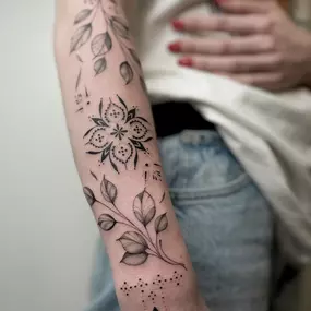 Ornamental Tattoo mit Mandala und floralen Elementen. Angebracht auf dem Unterarm und teilweise auf der Hand.