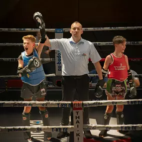 aerolibrium - Fitness-, Sport- & Kampfsport Fotografie - Augsburg Dynamischer Moment eines Kickboxturniers, festgehalten beim Siegesruf nach einem intensiven Wettkampf im Ring.