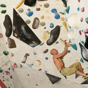 aerolibrium - Fitness-, Sport- & Kampfsport Fotografie - Augsburg Authentisches Bild eines Kletterers an einer Indoor-Boulderwand, das Technik, Kraft und Balance betont.