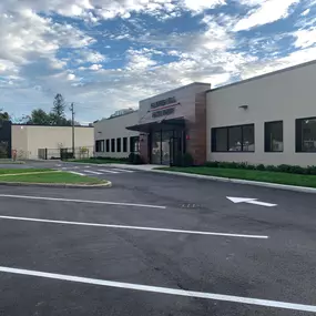 A wide-angle view of Flower Hill Auto Body of Huntington’s modern facility at 15 West Stepar Place in Huntington Station, NY. The clean architectural lines, updated landscaping, and freshly paved parking area reflect the shop’s commitment to precision, professionalism, and exceptional customer service.