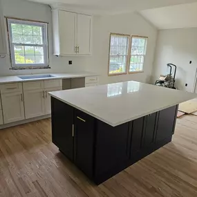 Modern kitchen remodel featuring a black island, white cabinetry, and quartz countertops. Selective Remodeling delivers premium kitchen renovations
