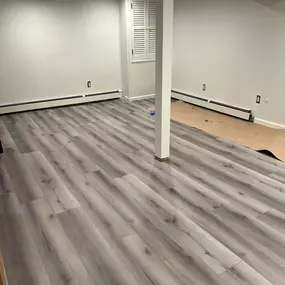 A modern basement renovation featuring updated flooring, fresh walls, and a bright, open layout. Selective Remodeling specializes in basement finishing across Long Island.