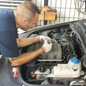 Mitarbeiter arbeitet an geöffneter Motorhaube