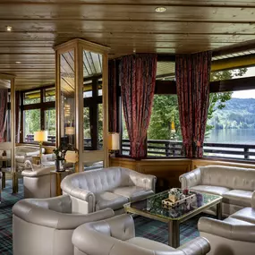 Die Lobby des Maritim Hotels Titisee bietet eine einladende Atmosphäre mit gemütlichen Sesseln. Der stilvoll gestaltete Bereich lädt zum Entspannen und Verweilen ein, umgeben von rustikalem Design und entspannender Beleuchtung.