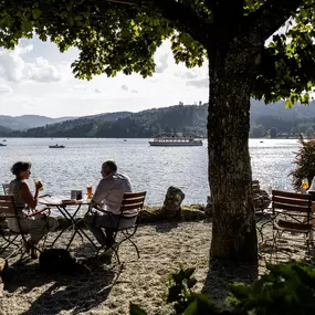 Der Biergarten des Maritim Hotels Titisee lädt mit gemütlichen Sitzplätzen im Freien und rustikalem Charme zum Entspannen ein. Gäste genießen erfrischende Getränke und Snacks in einer angenehmen Umgebung.