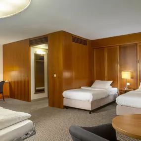 Das Familienzimmer im Maritim Hotel Stuttgart bietet Komfort für die ganze Familie, mit Doppelbett, Schlafsofa, Arbeitsbereich und Blick auf den Hoppenlau-Park.