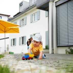 Die FRÖBEL-Kinderkrippe Marchioninistraße in München-Hadern mit Blick vom Garten auf das Gebäude © 2022 FRÖBEL e.V. Alle Rechte vorbehalten