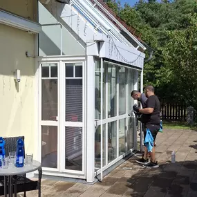 Bild von fensterfee reinigt Glas und Gebäude