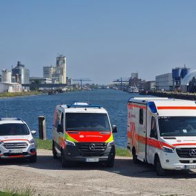 Drei Einsatzfahrzeuge der Johanniter in Kehl vor der Kulisse des Kehler Rheinhafens.